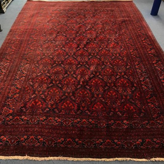 A Persian red ground carpet, with field of palmette motifs, multi-bordered 339 x 230cm